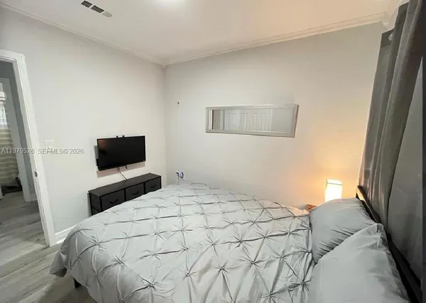a bedroom with a bed and a flat screen tv