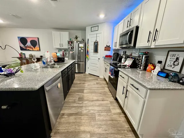 a kitchen with kitchen island granite countertop lots of counter top space and stainless steel appliances