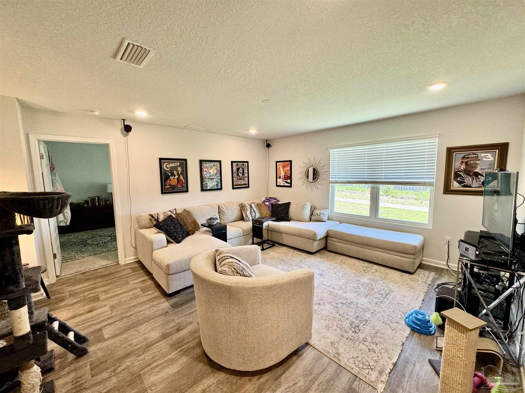 5645 Guinevere Lane Milton, FL 32583 - Photo 17 of 24 a living room with furniture and a flat screen tv