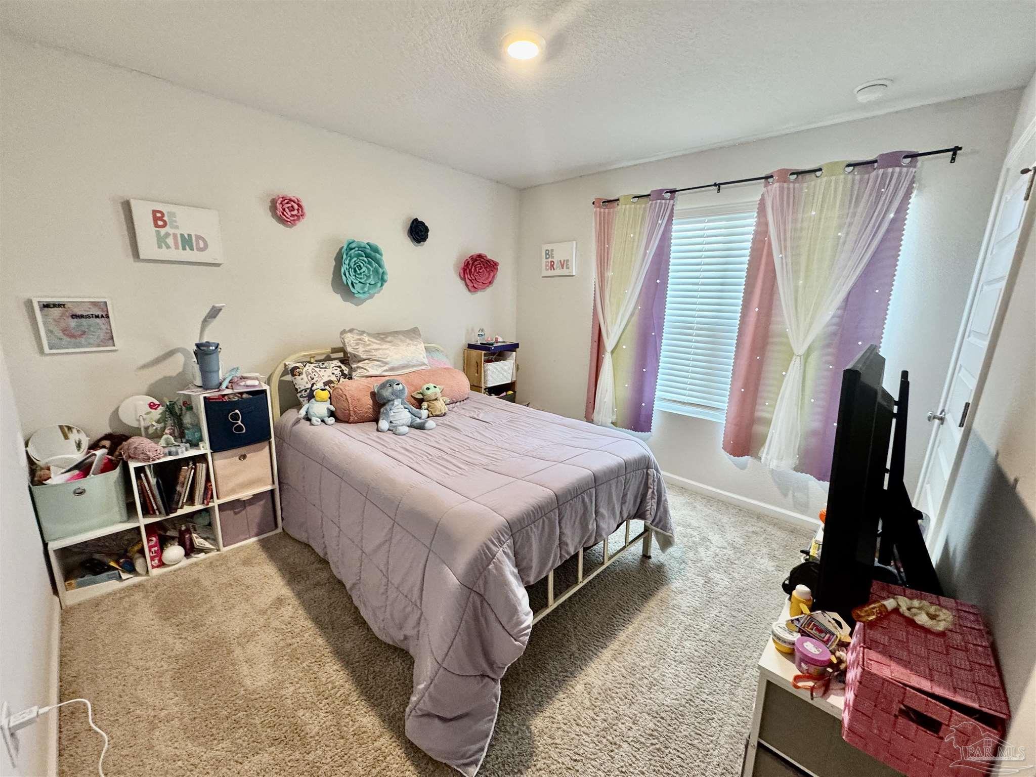 5645 Guinevere Lane Milton, FL 32583 - Photo 5 of 24 a bedroom with a bed and a flat screen tv