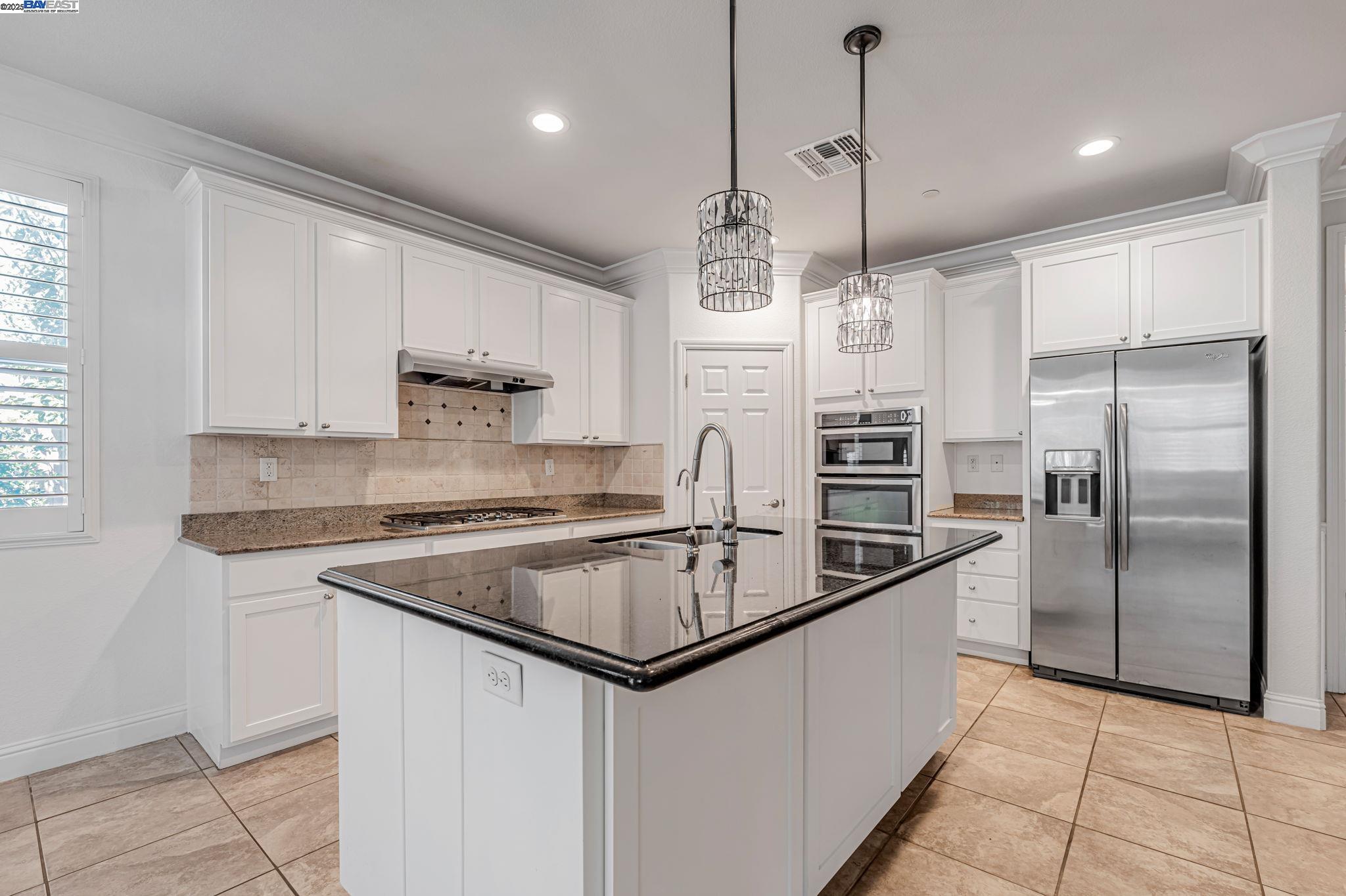 2491 Redbud Way Manteca, CA 95336 - Photo 2 of 27 a kitchen with stainless steel appliances granite countertop a sink a stove a refrigerator and island