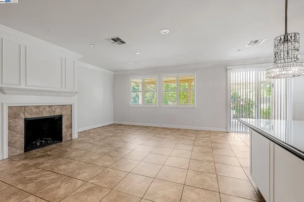 a view of an empty room with a fireplace and a window