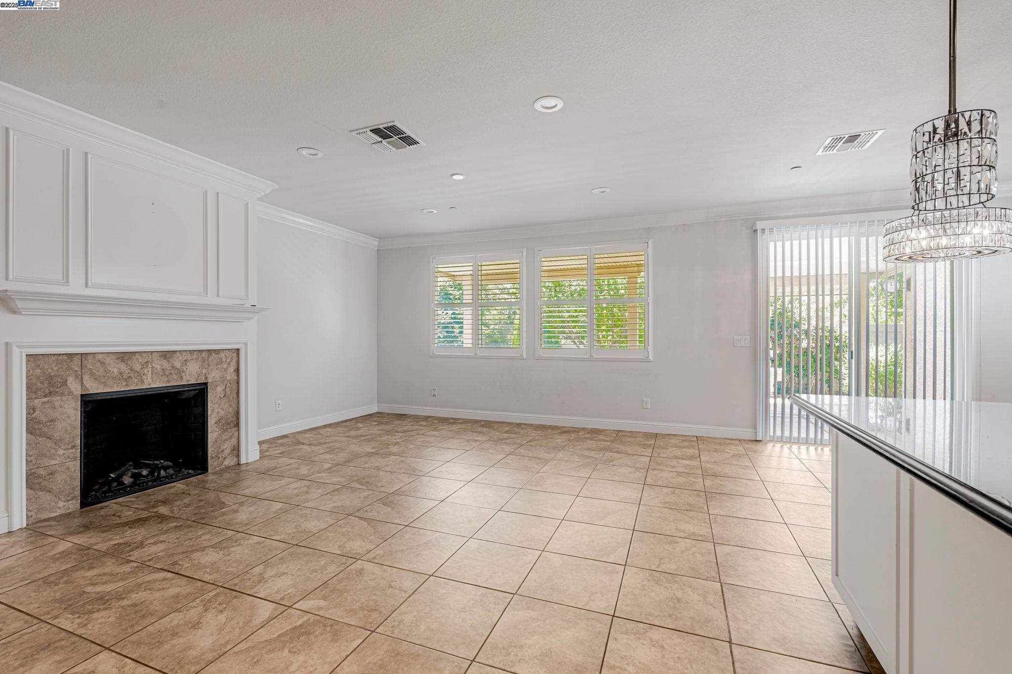 2491 Redbud Way Manteca, CA 95336 - Photo 4 of 27 a view of an empty room with a fireplace and a window