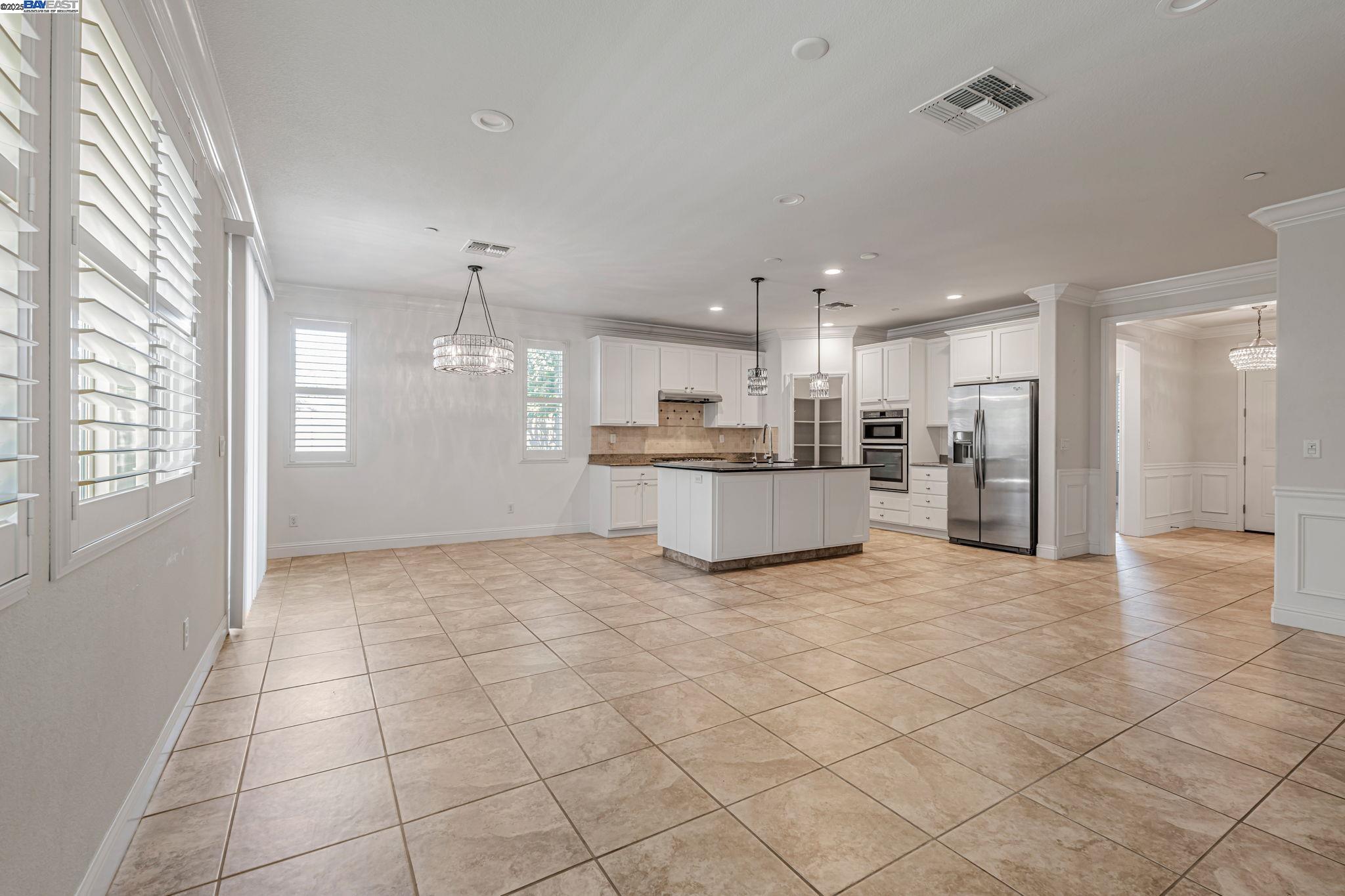 2491 Redbud Way Manteca, CA 95336 - Photo 6 of 27 a kitchen with stainless steel appliances kitchen island granite countertop a sink and cabinets