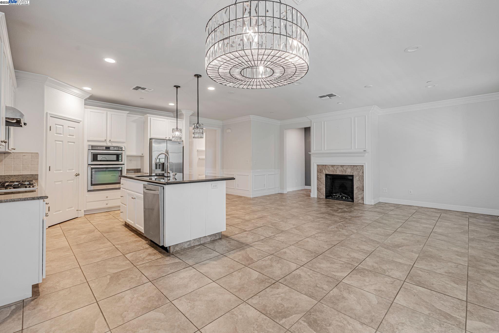 2491 Redbud Way Manteca, CA 95336 - Photo 8 of 27 a kitchen with stainless steel appliances granite countertop a stove top oven a sink a counter top space and cabinets