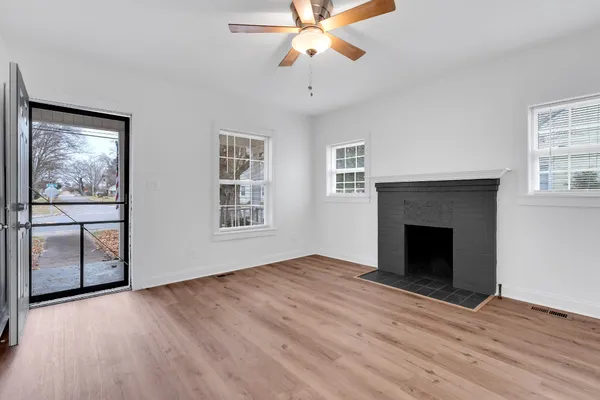 an empty room with windows and fireplace