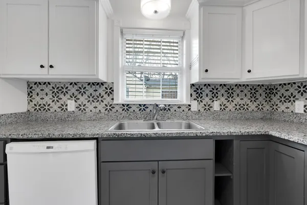 a kitchen with granite countertop a sink and a window