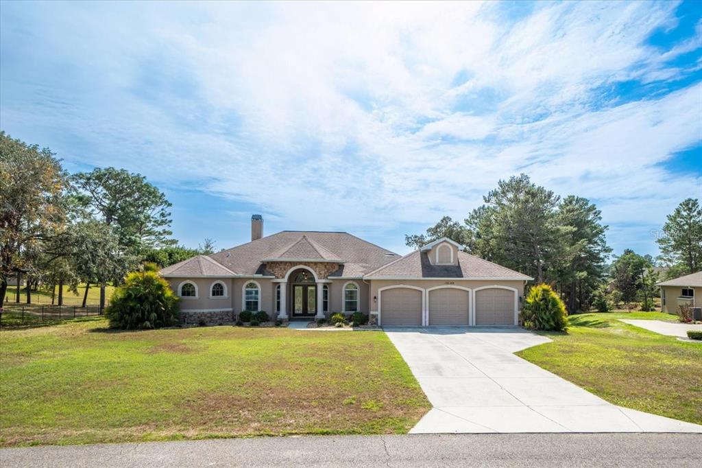 10188 Whisper Ridge Trail Weeki Wachee, FL 34613 - Photo 1 of 1 a front view of a house with a yard