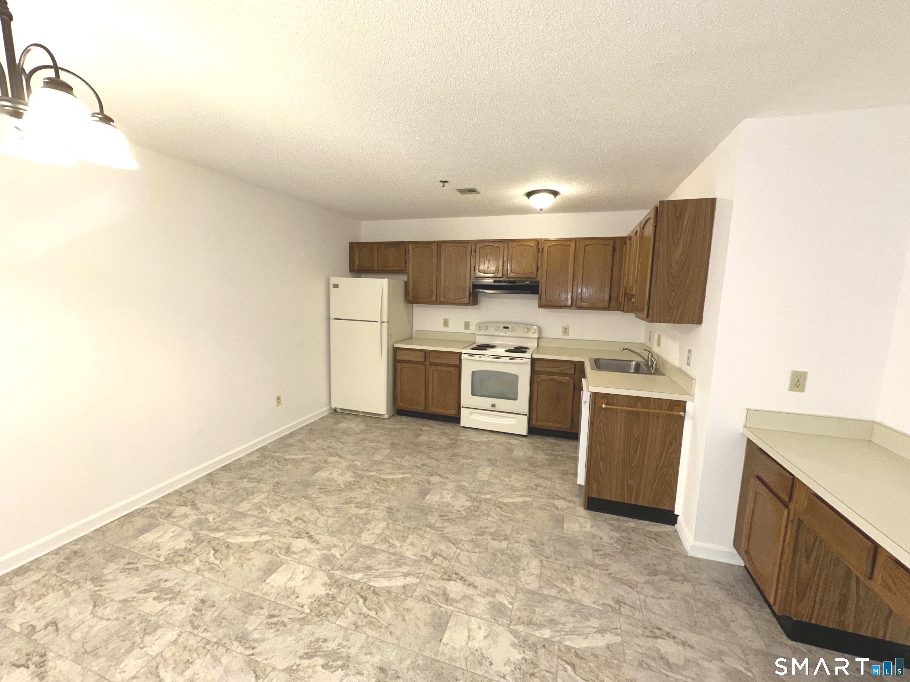 243 Judd Square, Unit 243 Wallingford, CT 06492 - Photo 5 of 17 a kitchen with a stove top oven and cabinets