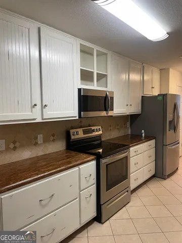 a kitchen with granite countertop white cabinets and sink
