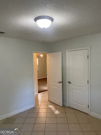 an empty room with closet and windows