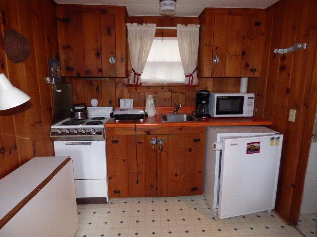 75 Beaten Road, Unit 9 Dennis Port, MA 02639 - Photo 7 of 14 a kitchen with a sink a stove and a refrigerator