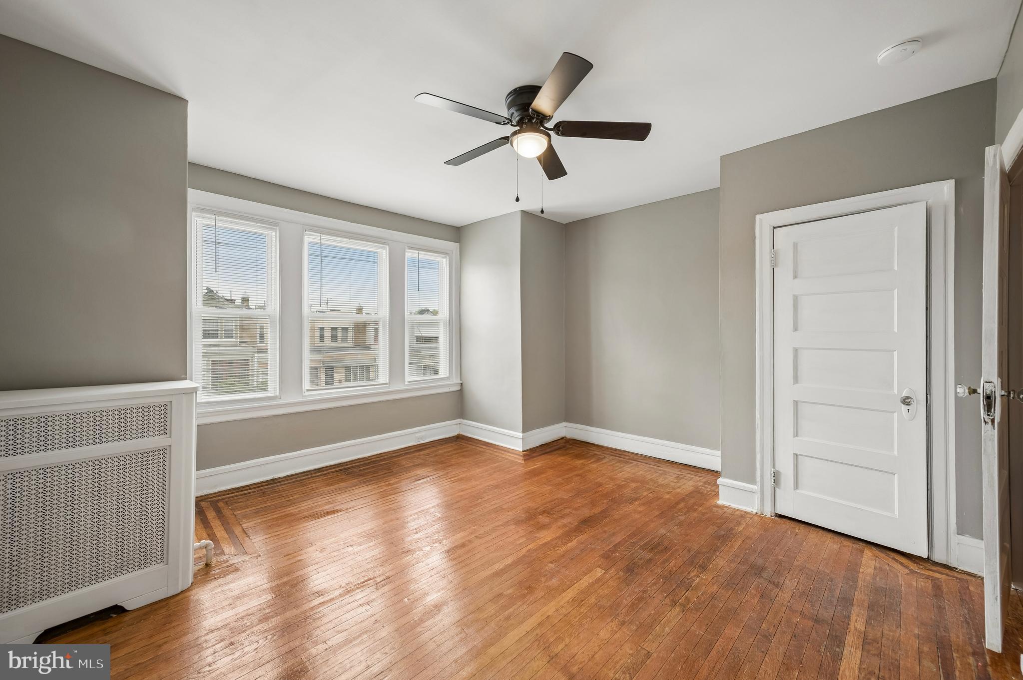 5625 Willows Avenue Philadelphia, PA 19143 - Photo 10 of 15 an empty room with wooden floor fan and windows