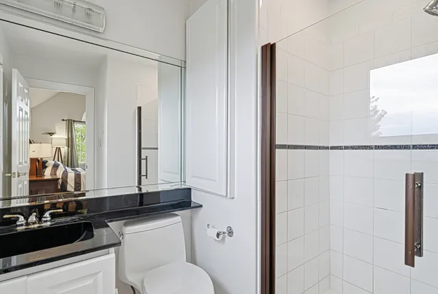 a bathroom with a sink vanity mirror and toilet