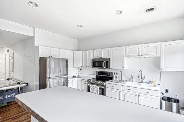a kitchen with stainless steel appliances a refrigerator stove microwave and sink