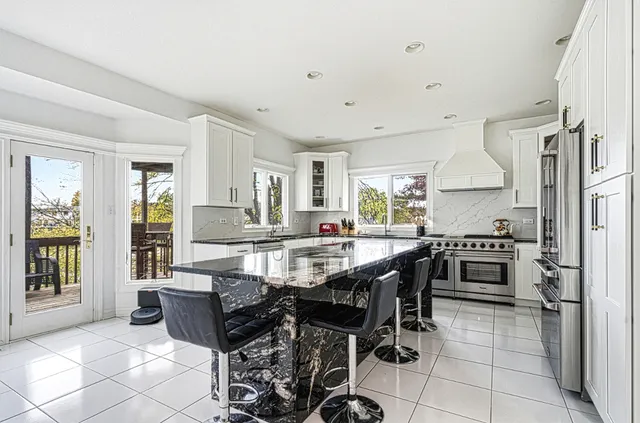a large kitchen with kitchen island a large counter space and stainless steel appliances