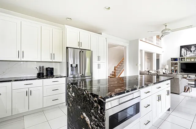 a kitchen with white cabinets and appliances