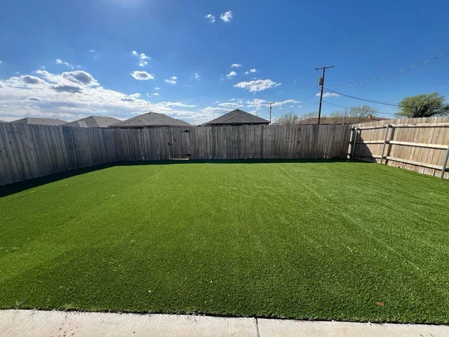 a view of a backyard with wooden fence