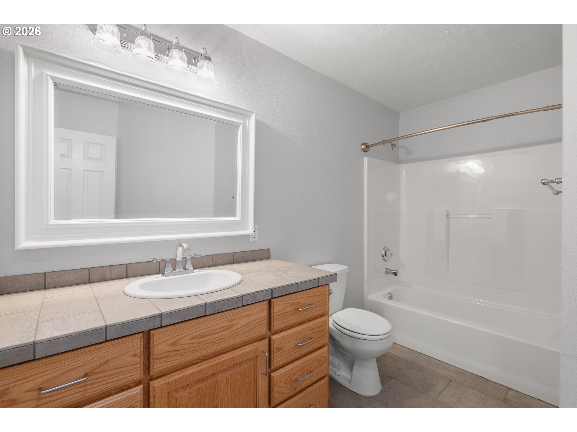5720 Sollie Smith Road North Tillamook, OR 97141 - Photo 24 of 44 a bathroom with a granite countertop sink toilet a large mirror a bathtub and shower