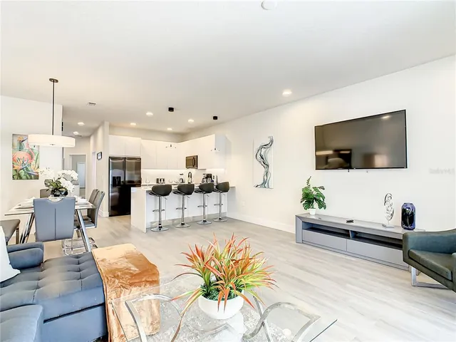 a kitchen with stainless steel appliances granite countertop a stove top oven a sink and a refrigerator