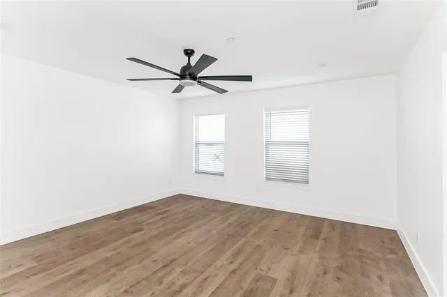 a view of a livingroom with a ceiling fan and wooden floor