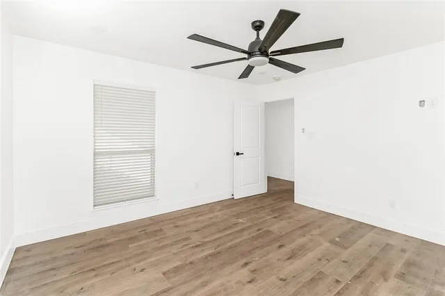 a view of a big room with wooden floor closet and windows