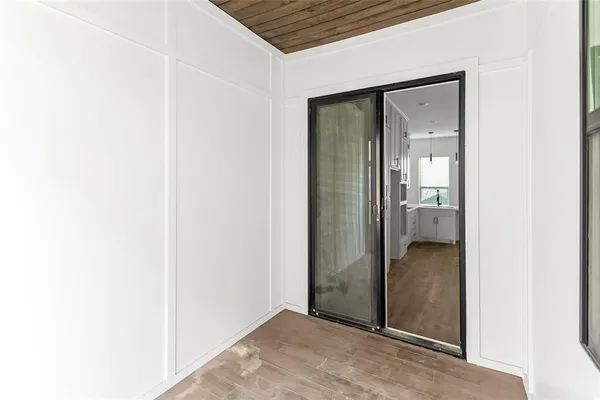 a view of a room with wooden floor and a ceiling fan