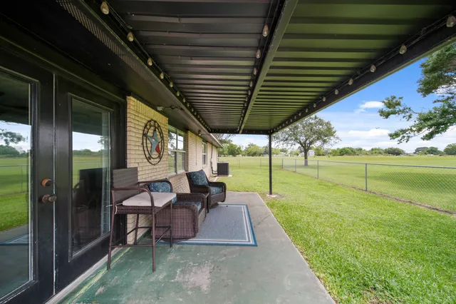 a view of a porch with chairs and backyard