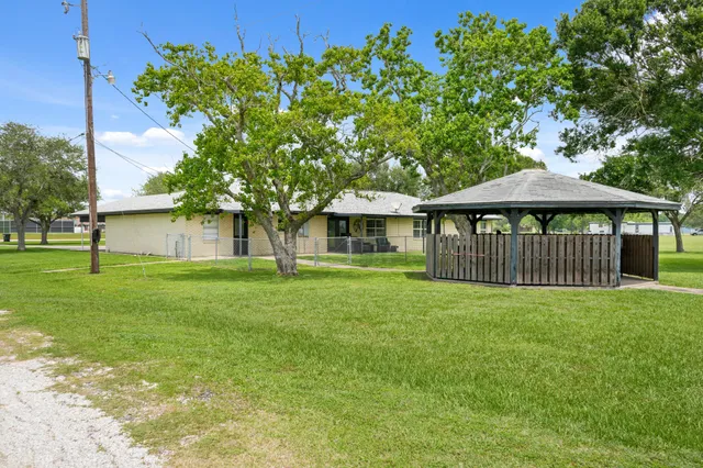 a view of a house with a yard and sitting area