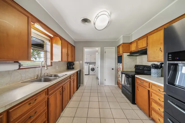 a large kitchen with stainless steel appliances granite countertop a sink and cabinets
