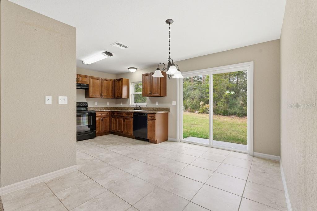 16592 Southwest 31st Circle Ocala, FL 34473 - Photo 14 of 27 a open kitchen with kitchen island a large window and stainless steel appliances