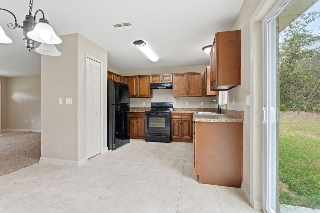 16592 Southwest 31st Circle Ocala, FL 34473 - Photo 15 of 27 a kitchen with stainless steel appliances granite countertop a refrigerator a oven a sink with a dining table and chairs