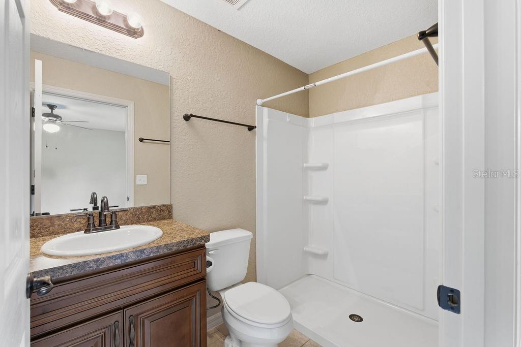 16592 Southwest 31st Circle Ocala, FL 34473 - Photo 20 of 27 a bathroom with a granite countertop sink toilet a mirror and shower