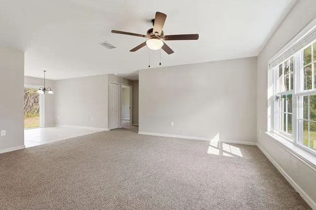 a view of a livingroom with a ceiling fan and window