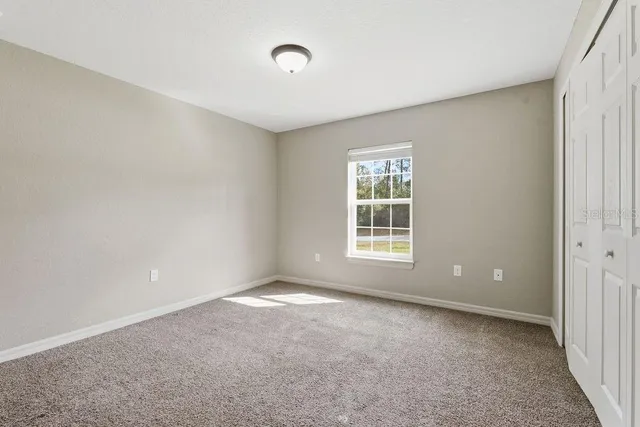 a view of a big room with windows and chandelier fan