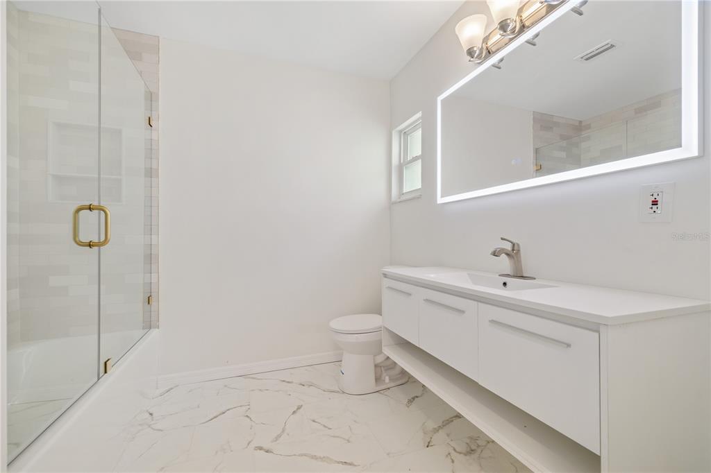 8916 Memorial Highway Tampa, FL 33615 - Photo 14 of 26 a bathroom with a toilet sink and mirror
