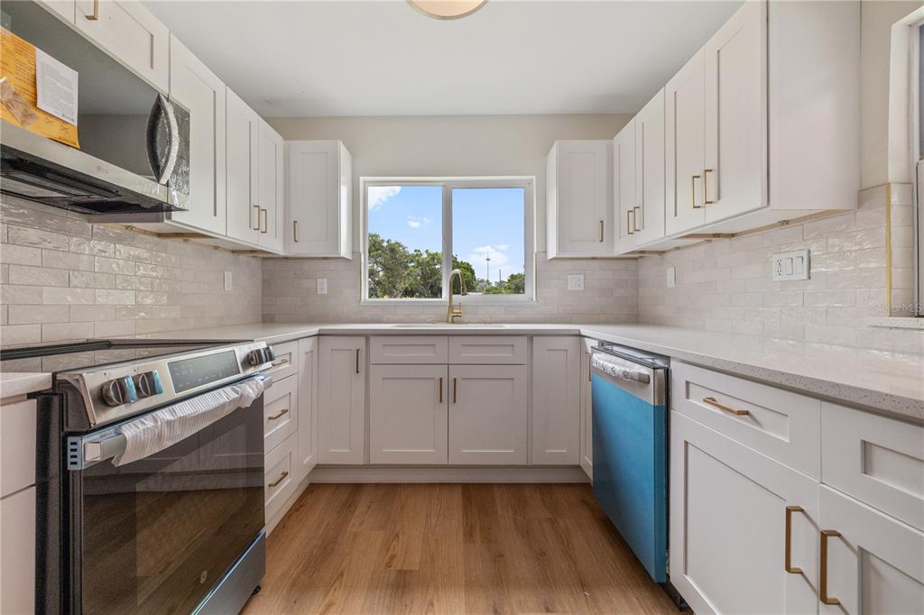 8916 Memorial Highway Tampa, FL 33615 - Photo 7 of 26 a kitchen with a sink stove and cabinets