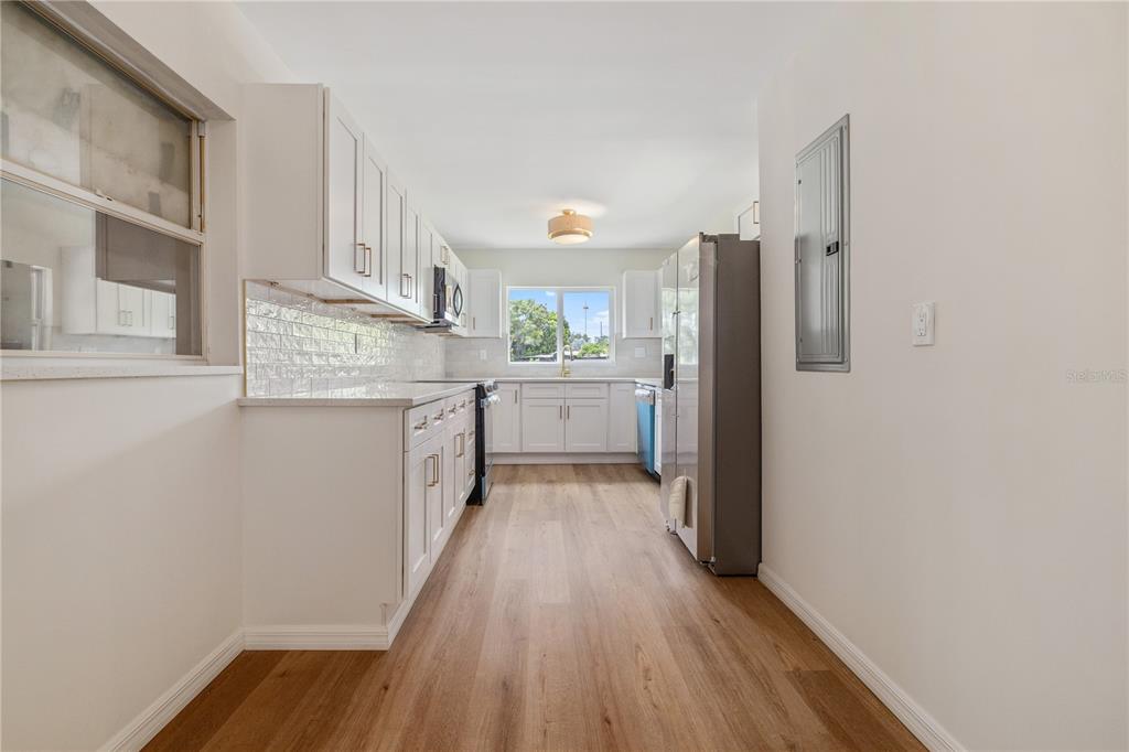8916 Memorial Highway Tampa, FL 33615 - Photo 9 of 26 a kitchen with a white cabinets and wooden floor