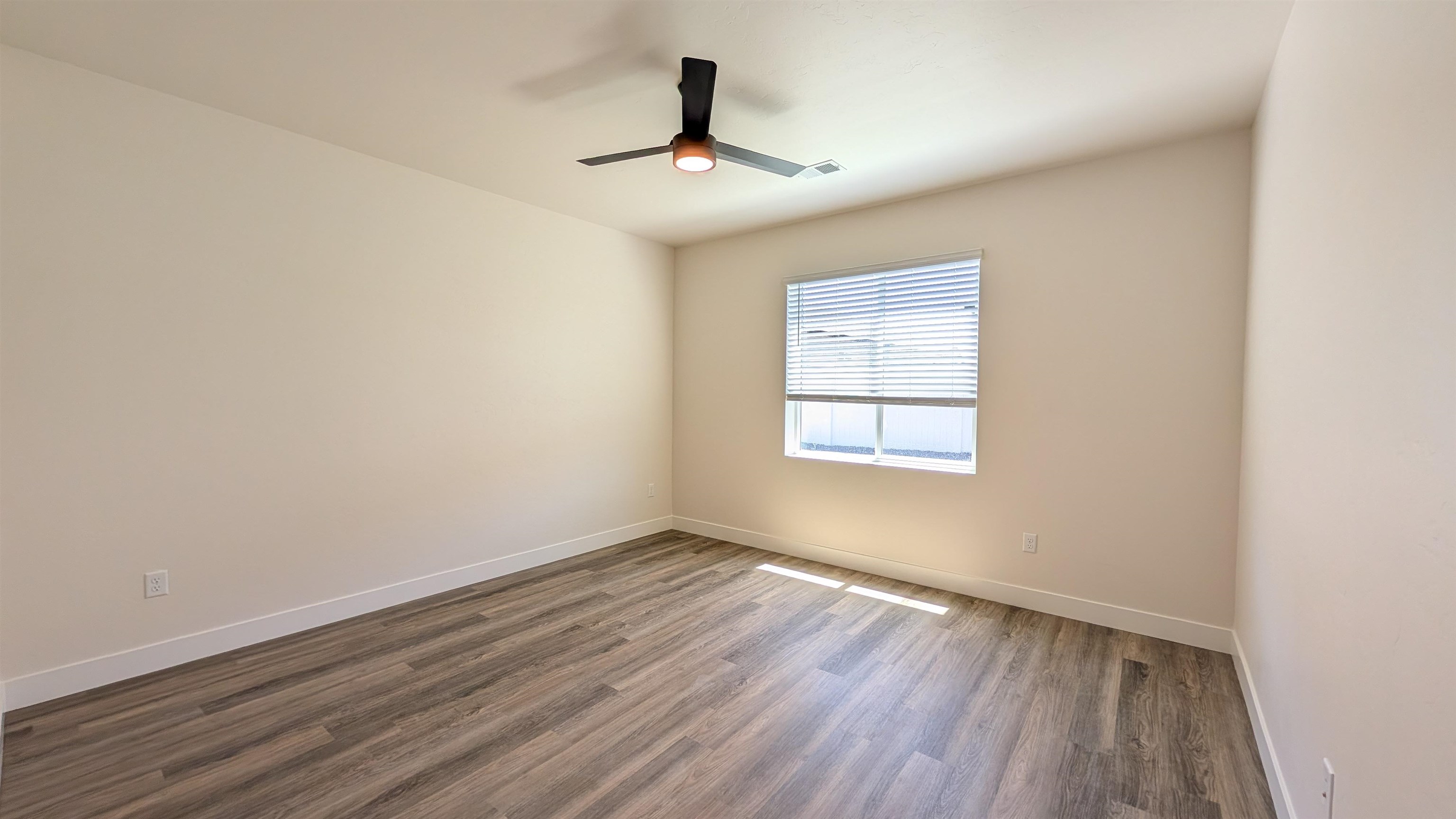 1660 Rusty Rivet Road Fruita, CO 81521 - Photo 9 of 15 a view of an empty room with wooden floor and a window