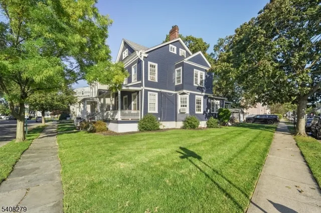 a front view of a house with a yard and trees