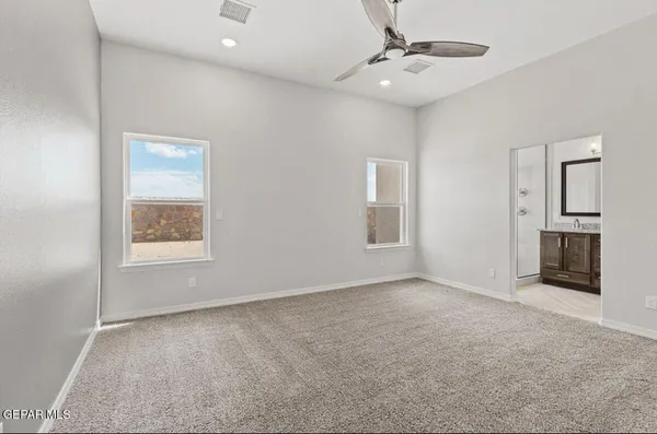 an empty room with windows and cabinet