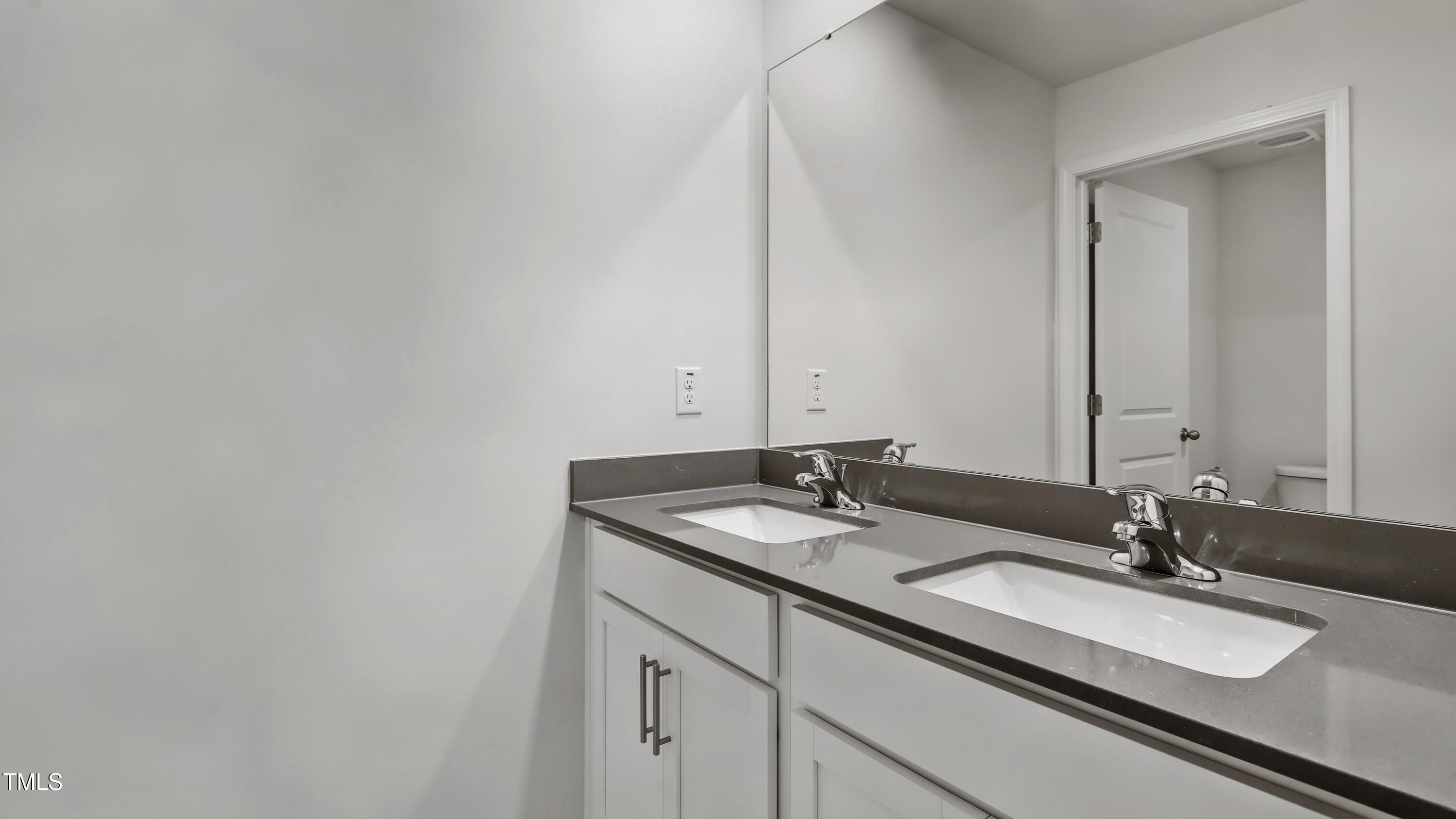 821 Comice Pear Way Willow Spring, NC 27592 - Photo 30 of 36 a bathroom with a granite countertop sink and a mirror