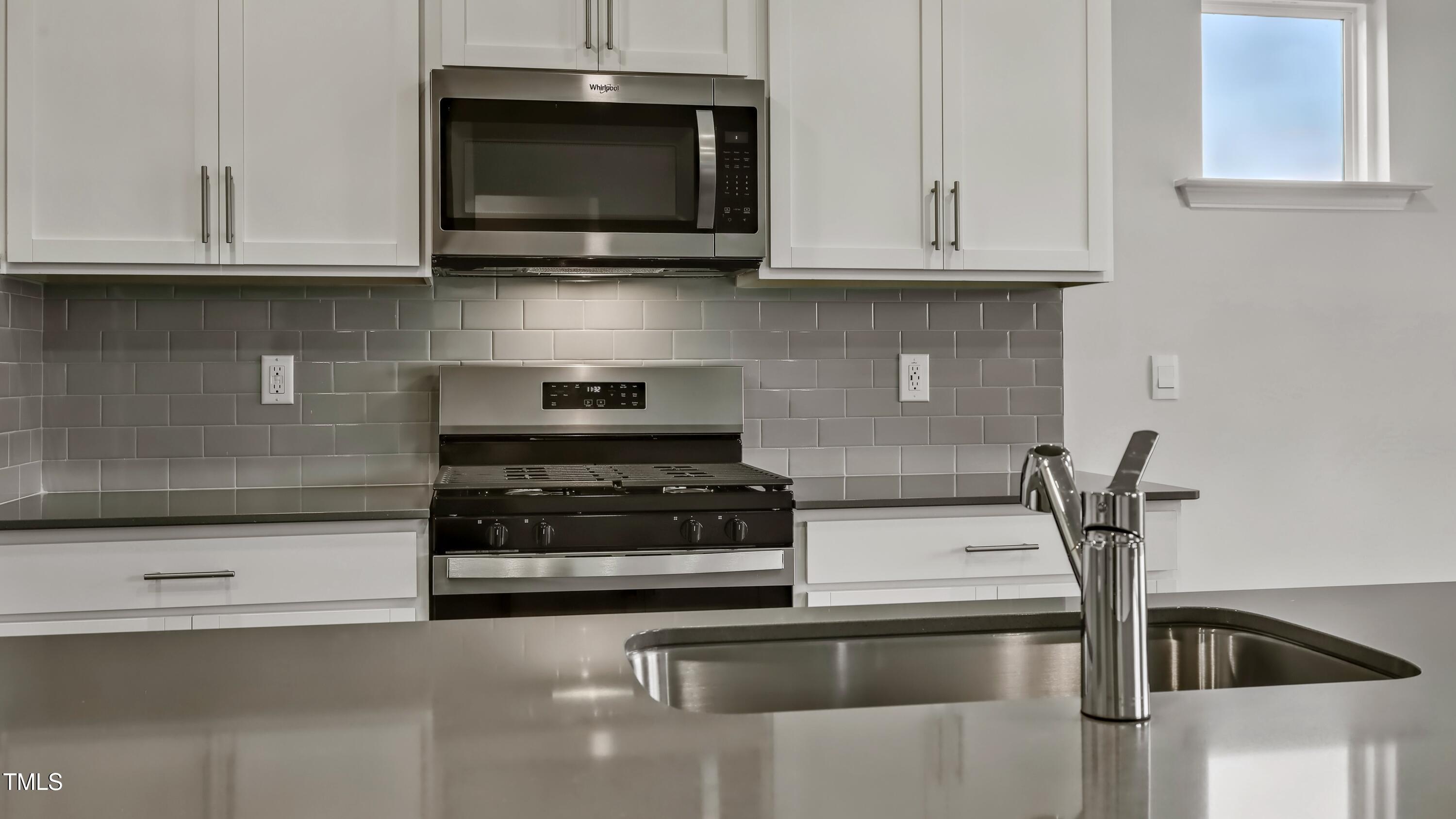821 Comice Pear Way Willow Spring, NC 27592 - Photo 9 of 36 a kitchen with stainless steel appliances granite countertop a sink and a microwave