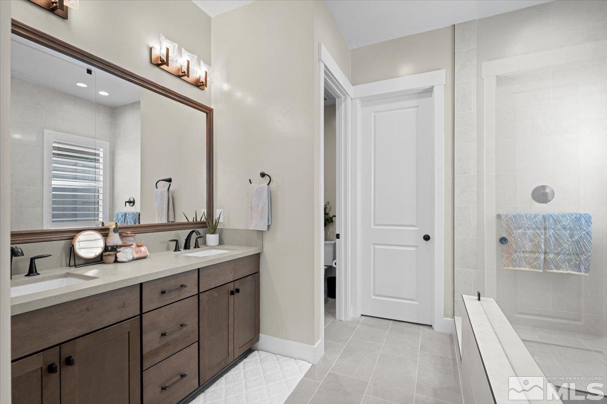 5566 Western Rider Trail Reno, NV 89511 - Photo 17 of 40 a spacious bathroom with a double vanity sink a large mirror and shower