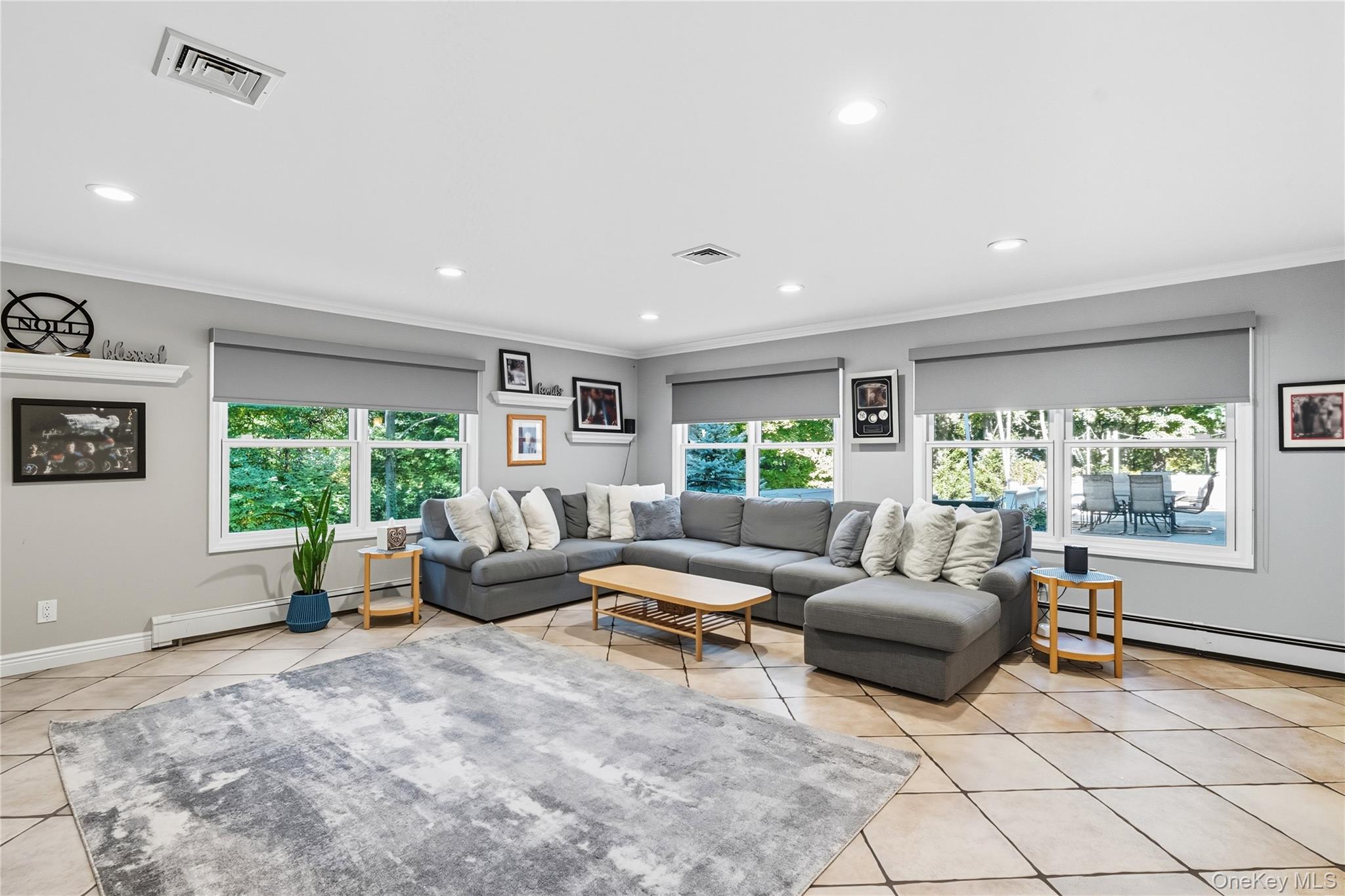 16 Pine Road Syosset, NY 11791 - Photo 16 of 48 Living area with crown molding, light tile patterned flooring, plenty of natural light, a baseboard radiator, and recessed lighting