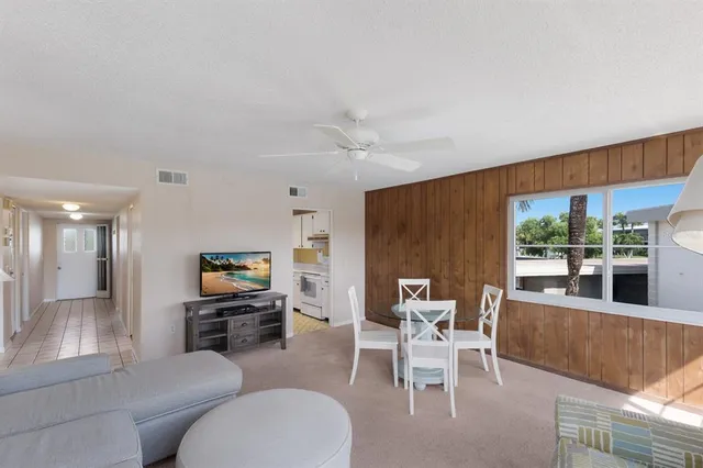 a living room with furniture and a open kitchen view