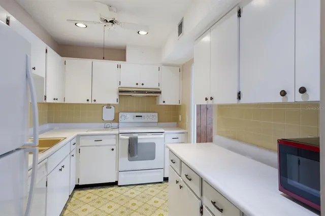 a kitchen with a sink stove and cabinets