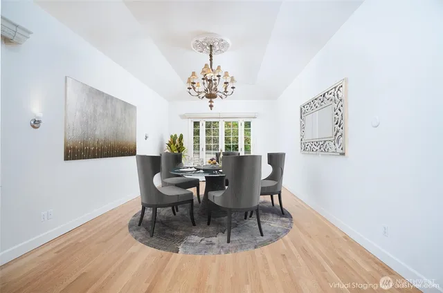 a dining room with wooden floor and a chandelier