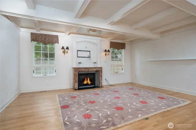 a view of an empty room with window and fire place