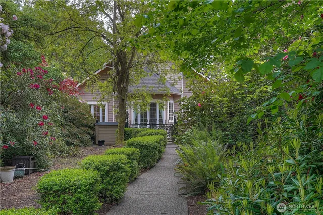 a front view of a house with plants and trees